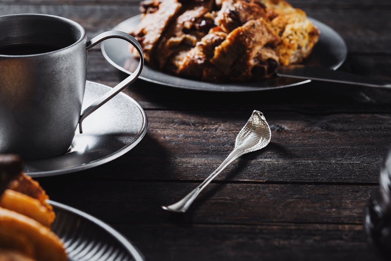 Elegant breakfast setup with coffee and pastries on a rustic wooden table, offering a cozy and inviting ambiance.