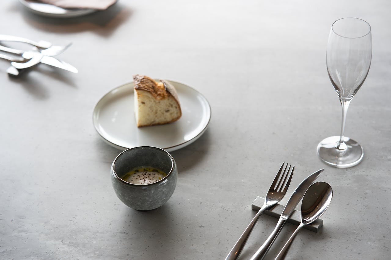 Elegant dining setup featuring bread and cutlery on a minimalist table in Tokyo, Japan.
